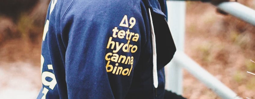 Un sweat-shirt bleu avec la formule chimique du THC imprimée sur la manche.