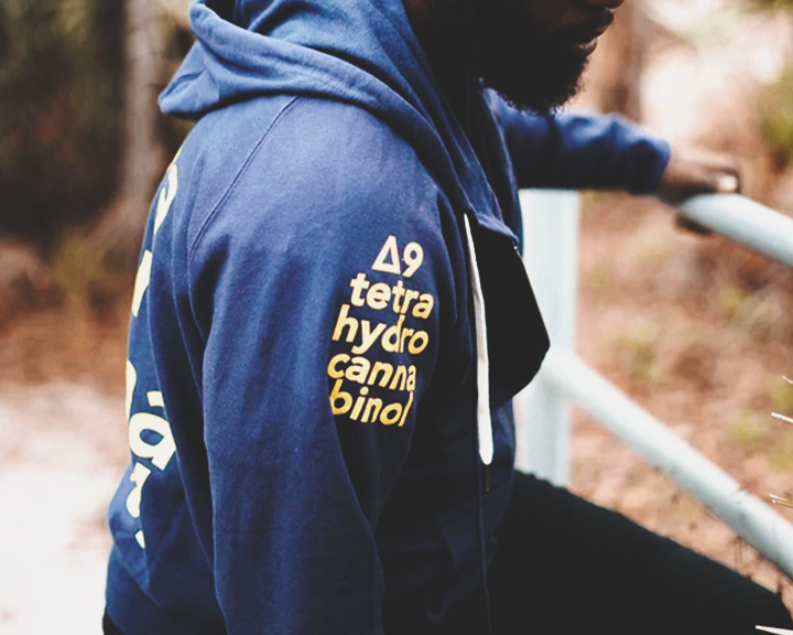 Un sweat-shirt bleu avec la formule chimique du THC imprimée sur la manche.