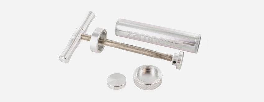Une seringue métallique argentée avec une poignée et un piston.