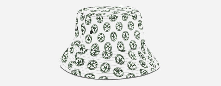 Un bob blanc avec un motif de feuilles de marijuana vertes.