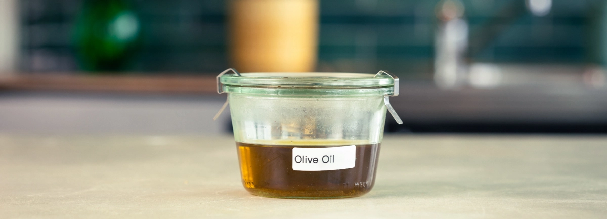 Conservation de l’huile d’olive infusée au cannabis Récipient en verre d’huile d’olive infusée au cannabis, étiqueté et prêt à être conservé.