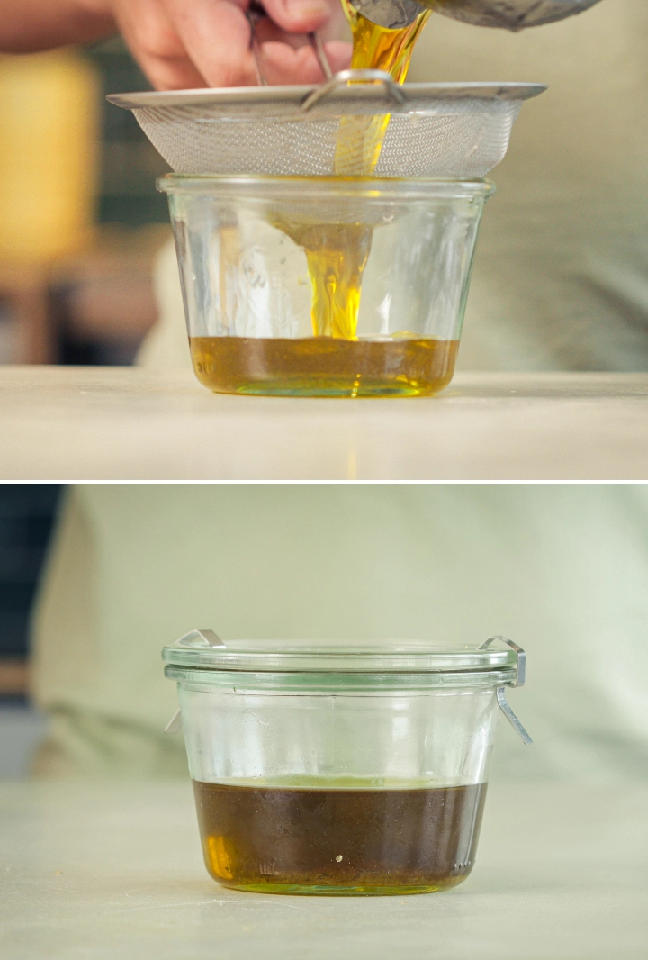 Filtration de l’huile d’olive infusée au cannabis Huile d’olive infusée au cannabis filtrée à travers un tamis fin dans un récipient en verre.