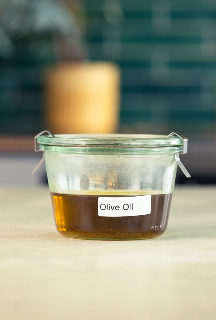Conservation de l’huile d’olive infusée au cannabis Récipient en verre d’huile d’olive infusée au cannabis, étiqueté et prêt à être conservé.