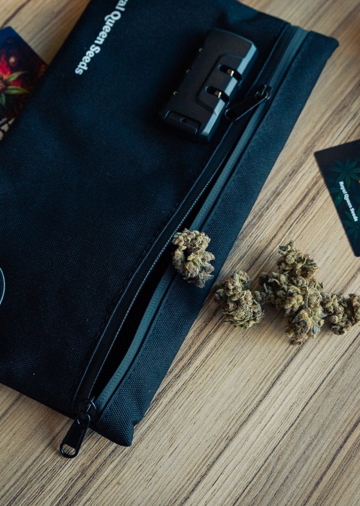 Sac de rangement discret pour stocker le cannabis Image d’un sac de rangement verrouillable avec des têtes de cannabis sur une surface en bois.