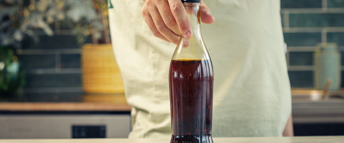 Étape 4 : Conserver Correctement l’Huile au Piment Infusée au Cannabis Bouteille en verre scellée remplie d’huile au piment infusée au cannabis, conservée dans une cuisine