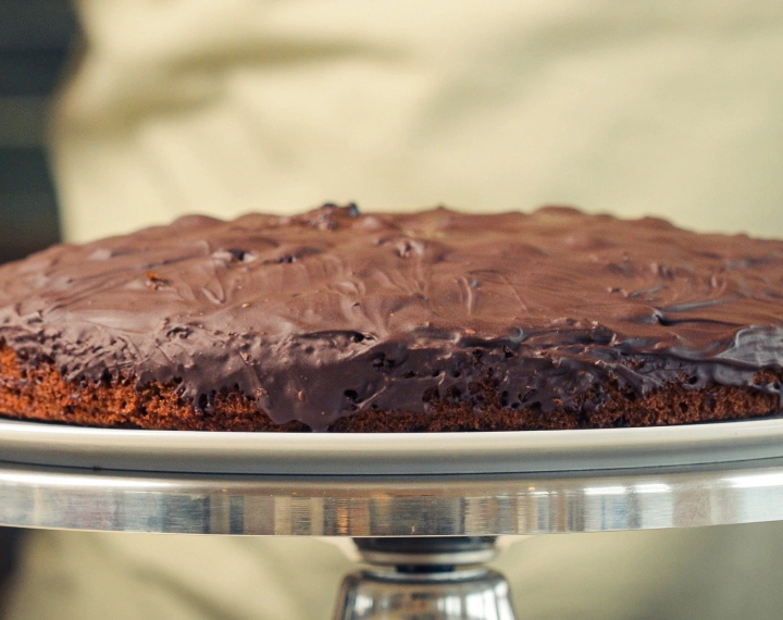 Space cake maison au cannabis terminé, recouvert de chocolat noir fondu, servi comme un dessert comestible classique